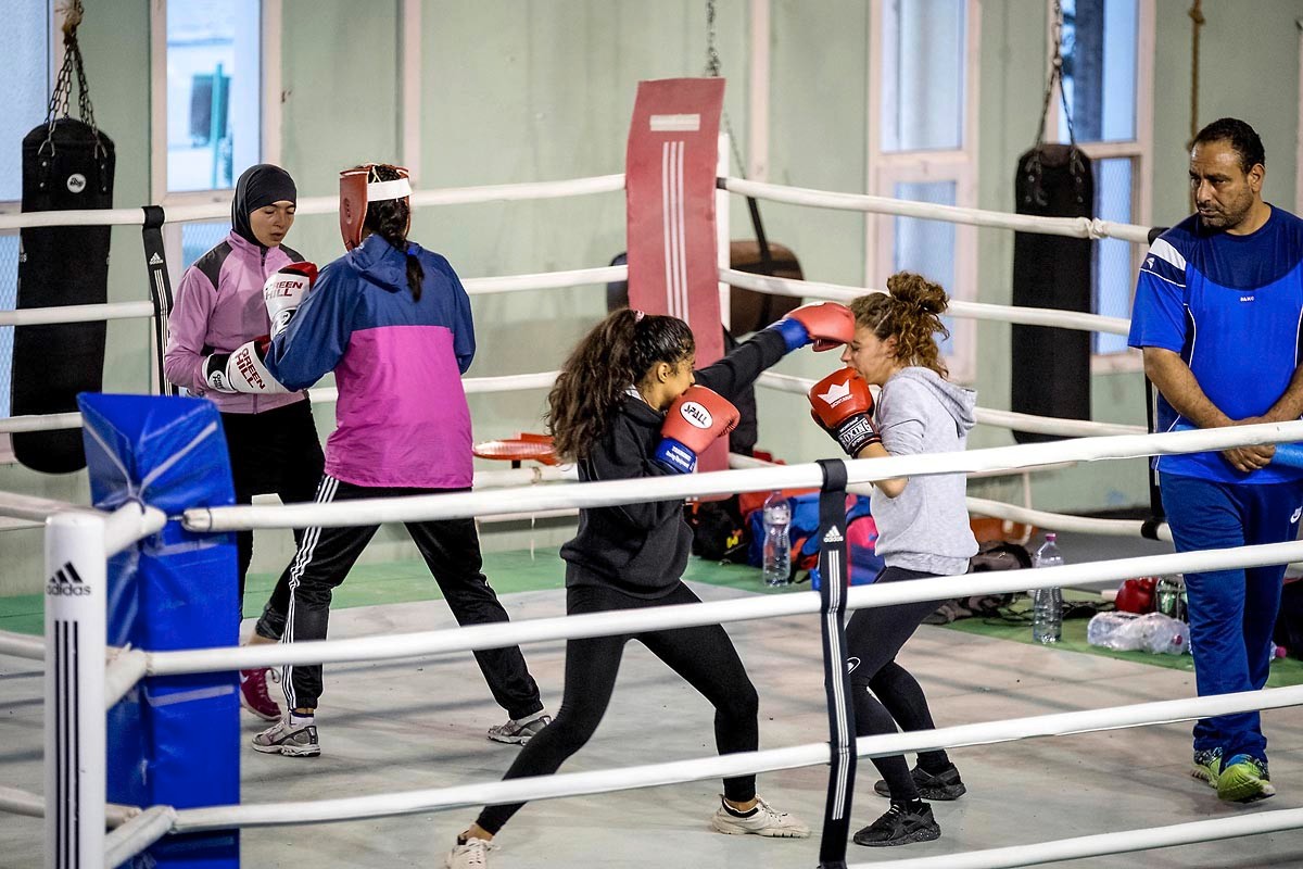 Le ring occupé par plusieurs paires en rotation, l'entraîneur à droite du cadre.