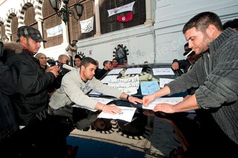 journée du 21/01/2011 : Sur la voiture du Premier Ministre les manifestants placardent leurs messages de mécontentement durant la manifestation sur la Place de la Kasbah devant les portes du Premier Ministère, le peuple tout uni demande la démission du Premier Ministre M. Ghanouchi, cette manifestation verra un mouvement spontané des policiers qui décident de manifester pour ecrtains d'entre eux avec le peuple tout en s'excusant pour tous ses actes faits durant la dictature policère de Ben Ali.