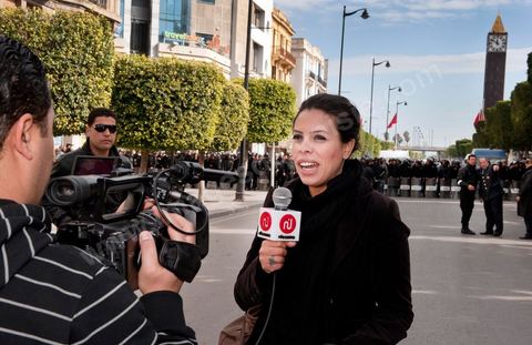 Journaliste de la télévision satellitaire privé tunisienne couvrant une manifestation de l'UGTT et interviewant les militaires sur l'avenue Habib Bourguiba à Tunis. Les journalistes tunisiens découvrent une liberté de la presse et investissent le terrain.
