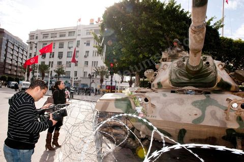 Journaliste de la télévision satellitaire privé tunisienne couvrant une manifestation de l'UGTT et interviewant les militaires sur l'avenue Habib Bourguiba à Tunis. Les journalistes tunisiens découvrent une liberté de la presse et investissent le terrain.