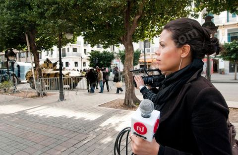 Journaliste de la télévision satellitaire privé tunisienne couvrant une manifestation de l'UGTT et interviewant les militaires sur l'avenue Habib Bourguiba à Tunis. Les journalistes tunisiens découvrent une liberté de la presse et investissent le terrain.