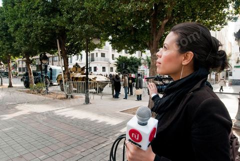 Journaliste de la télévision satellitaire privé tunisienne couvrant une manifestation de l'UGTT et interviewant les militaires sur l'avenue Habib Bourguiba à Tunis. Les journalistes tunisiens découvrent une liberté de la presse et investissent le terrain.