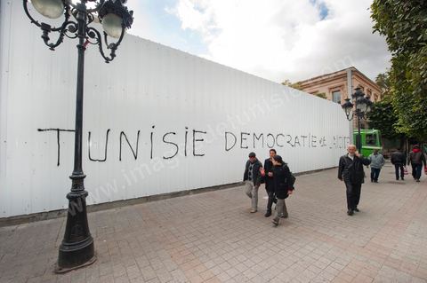 On the city walls, slogans and signs from the People's Revolution protesters are displayed in Arabic and French.