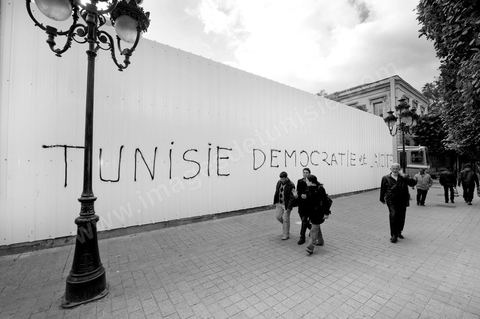 On the city walls, slogans and signs from the People's Revolution protesters are displayed in Arabic and French.