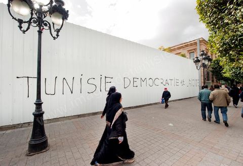 On the city walls, slogans and signs from the People's Revolution protesters are displayed in Arabic and French.