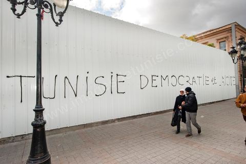 On the city walls, slogans and signs from the People's Revolution protesters are displayed in Arabic and French.