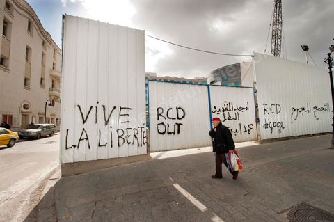 On the city walls, slogans and signs from the People's Revolution protesters are displayed in Arabic and French.