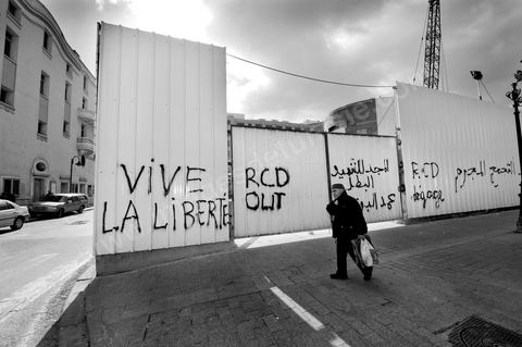 On the city walls, slogans and signs from the People's Revolution protesters are displayed in Arabic and French.