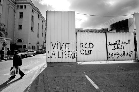 On the city walls, slogans and signs from the People's Revolution protesters are displayed in Arabic and French.