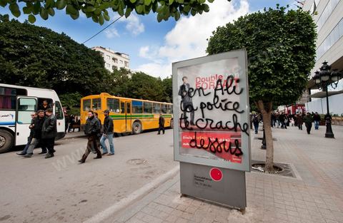 On the city walls, slogans and signs from the People's Revolution protesters are displayed in Arabic and French.