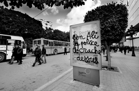 On the city walls, slogans and signs from the People's Revolution protesters are displayed in Arabic and French.