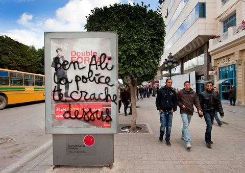 On the city walls, slogans and signs from the People's Revolution protesters are displayed in Arabic and French.