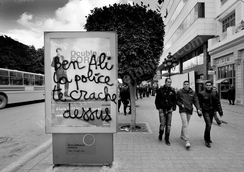On the city walls, slogans and signs from the People's Revolution protesters are displayed in Arabic and French.