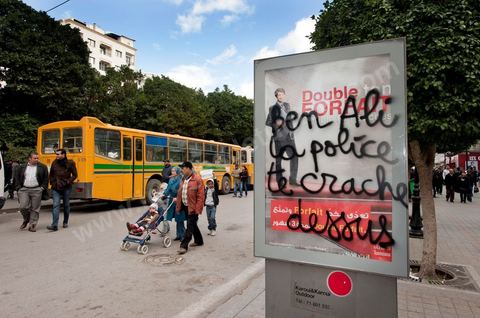 On the city walls, slogans and signs from the People's Revolution protesters are displayed in Arabic and French.