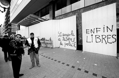 On the city walls, slogans and signs from the People's Revolution protesters are displayed in Arabic and French.