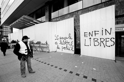 On the city walls, slogans and signs from the People's Revolution protesters are displayed in Arabic and French.