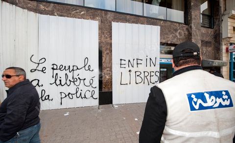 On the city walls, slogans and signs from the People's Revolution protesters are displayed in Arabic and French.