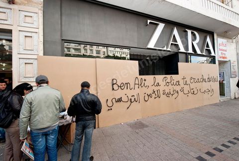 On the city walls, slogans and signs from the People's Revolution protesters are displayed in Arabic and French.