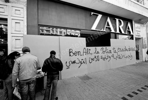 On the city walls, slogans and signs from the People's Revolution protesters are displayed in Arabic and French.