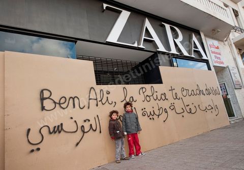 On the city walls, slogans and signs from the People's Revolution protesters are displayed in Arabic and French.