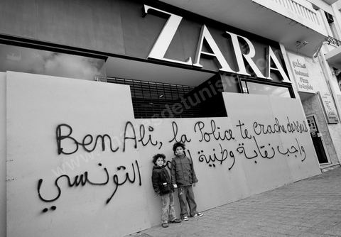 On the city walls, slogans and signs from the People's Revolution protesters are displayed in Arabic and French.