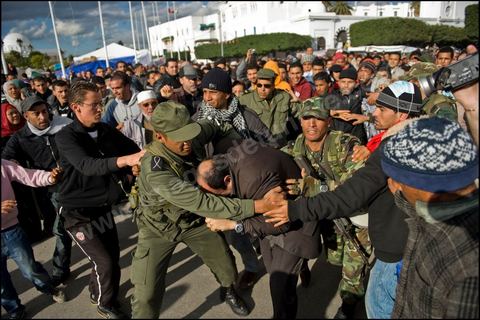 Military forces protect and evacuate a man from a crowd of protesters who accuse him of being a government infiltrator in support of the al-Kasbah government on January 28, 2011