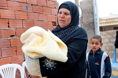 9 février : la maman de Mohamed avec le nouveau né de Salem, à la maison de Mohamed Bouazizi le 40ème jour de sa mort. Avec sa famille proche, mère, oncle, frère et soeurs, et amis du quartier célébration du 40ème jour de la mort de Mohamed Bouazizi. Dans la culture musulmane, le 40ème jour est le jour ou l'âme du défunt quitte la terre pour rejoindre le paradis, mùais aussi le jour où les parents doivent accepter ce départ de l'etre cher, le jour où l'on décrète la fin du deuil. ce jour là les proches de la famille viennent manger à la maison de la famille du défunt.