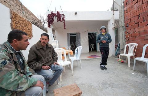 9 février : Salem le frère de Mohamed en discussion avec un ami et son fils ainé Karim. A la maison de Mohamed Bouazizi le 40ème jour de sa mort. Avec sa famille proche, mère, oncle, frère et soeurs, et amis du quartier célébration du 40ème jour de la mort de Mohamed Bouazizi. Dans la culture musulmane, le 40ème jour est le jour ou l'âme du défunt quitte la terre pour rejoindre le paradis, mùais aussi le jour où les parents doivent accepter ce départ de l'etre cher, le jour où l'on décrète la fin du deuil. ce jour là les proches de la famille viennent manger à la maison de la famille du défunt.