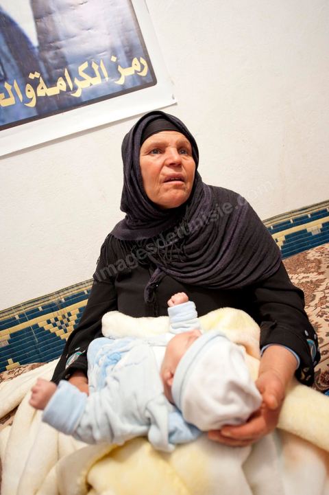 9 février : La maman de Mohamed avec Omar le nouveau né de Salem, frère de Mohamed, né le 17 décembre 2010, le jour de l'immolation de Mohamed Bouazizi. A la maison de Mohamed Bouazizi le 40ème jour de sa mort. Avec sa famille proche, mère, oncle, frère et soeurs, et amis du quartier célébration du 40ème jour de la mort de Mohamed Bouazizi. Dans la culture musulmane, le 40ème jour est le jour ou l'âme du défunt quitte la terre pour rejoindre le paradis, mùais aussi le jour où les parents doivent accepter ce départ de l'etre cher, le jour où l'on décrète la fin du deuil. ce jour là les proches de la famille viennent manger à la maison de la famille du défunt.