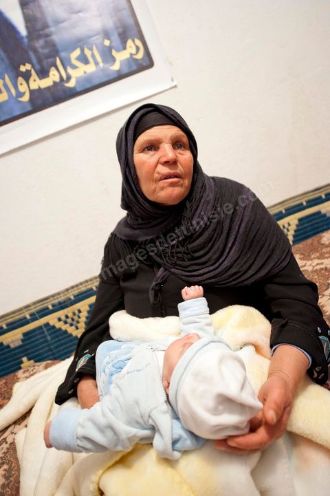 9 février : La maman de Mohamed avec Omar le nouveau né de Salem, frère de Mohamed, né le 17 décembre 2010, le jour de l'immolation de Mohamed Bouazizi. A la maison de Mohamed Bouazizi le 40ème jour de sa mort. Avec sa famille proche, mère, oncle, frère et soeurs, et amis du quartier célébration du 40ème jour de la mort de Mohamed Bouazizi. Dans la culture musulmane, le 40ème jour est le jour ou l'âme du défunt quitte la terre pour rejoindre le paradis, mùais aussi le jour où les parents doivent accepter ce départ de l'etre cher, le jour où l'on décrète la fin du deuil. ce jour là les proches de la famille viennent manger à la maison de la famille du défunt.