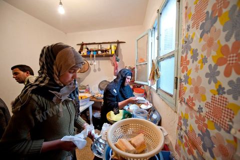 February 9: In the kitchen, Mohamed’s mother and her daughters prepare a meal for the guests at Mohamed Bouazizi’s home on the 40th day after his death. Together with his immediate family—his mother, uncle, brother, and sisters—and friends from the neighborhood, they celebrate the 40th day since Mohamed Bouazizi’s death. In Muslim culture, the 40th day is the day when the soul of the deceased leaves the earth to enter paradise; it is also the day when the family must accept the departure of their loved one—the day when the mourning period is declared over. On this day, close relatives gather to eat at the home of the deceased’s family.