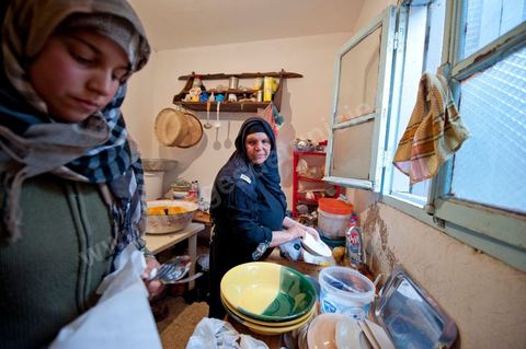 February 9: In the kitchen, Mohamed’s mother and her daughters prepare a meal for the guests at Mohamed Bouazizi’s home on the 40th day after his death. Together with his immediate family—his mother, uncle, brother, and sisters—and friends from the neighborhood, they celebrate the 40th day since Mohamed Bouazizi’s death. In Muslim culture, the 40th day is the day when the soul of the deceased leaves the earth to enter paradise; it is also the day when the family must accept the departure of their loved one—the day when the mourning period is declared over. On this day, close relatives gather to eat at the home of the deceased’s family.