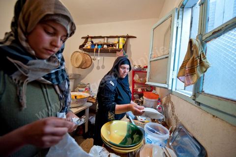 February 9: In the kitchen, Mohamed’s mother and her daughters prepare a meal for the guests at Mohamed Bouazizi’s home on the 40th day after his death. Together with his immediate family—his mother, uncle, brother, and sisters—and friends from the neighborhood, they celebrate the 40th day since Mohamed Bouazizi’s death. In Muslim culture, the 40th day is the day when the soul of the deceased leaves the earth to enter paradise; it is also the day when the family must accept the departure of their loved one—the day when the mourning period is declared over. On this day, close relatives gather to eat at the home of the deceased’s family.