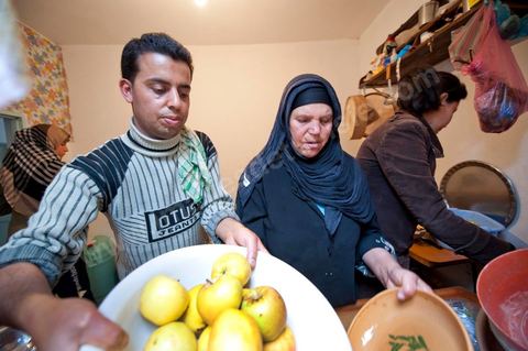 February 9: In the kitchen, Mohamed’s mother and her daughters prepare a meal for the guests at Mohamed Bouazizi’s home on the 40th day after his death. Together with his immediate family—his mother, uncle, brother, and sisters—and friends from the neighborhood, they celebrate the 40th day since Mohamed Bouazizi’s death. In Muslim culture, the 40th day is the day when the soul of the deceased leaves the earth to enter paradise; it is also the day when the family must accept the departure of their loved one—the day when the mourning period is declared over. On this day, close relatives gather to eat at the home of the deceased’s family.