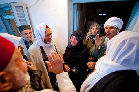 9 février : Les hommes venus prier et rendre hommage à Mohamed viennent saluer et soutenir la maman de Mohamed avant de se retirer. A la maison de Mohamed Bouazizi le 40ème jour de sa mort. Avec sa famille proche, mère, oncle, frère et soeurs, et amis du quartier célébration du 40ème jour de la mort de Mohamed Bouazizi. Dans la culture musulmane, le 40ème jour est le jour ou l'âme du défunt quitte la terre pour rejoindre le paradis, mùais aussi le jour où les parents doivent accepter ce départ de l'etre cher, le jour où l'on décrète la fin du deuil. ce jour là les proches de la famille viennent manger à la maison de la famille du défunt.