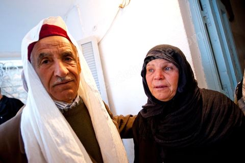 9 février : Les hommes venus prier et rendre hommage à Mohamed viennent saluer et soutenir la maman de Mohamed avant de se retirer. A la maison de Mohamed Bouazizi le 40ème jour de sa mort. Avec sa famille proche, mère, oncle, frère et soeurs, et amis du quartier célébration du 40ème jour de la mort de Mohamed Bouazizi. Dans la culture musulmane, le 40ème jour est le jour ou l'âme du défunt quitte la terre pour rejoindre le paradis, mùais aussi le jour où les parents doivent accepter ce départ de l'etre cher, le jour où l'on décrète la fin du deuil. ce jour là les proches de la famille viennent manger à la maison de la famille du défunt.
