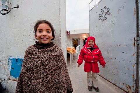 February 9: In front of Mohamed’s house, the family’s children are playing. At Mohamed Bouazizi’s home on the 40th day after his death. Together with his immediate family—his mother, uncle, brother, and sisters—and friends from the neighborhood, they are commemorating the 40th day since Mohamed Bouazizi’s death. In Muslim culture, the 40th day is the day when the soul of the deceased leaves the earth to enter paradise, but it is also the day when the family must accept the departure of their loved one—the day on which the mourning period is declared over. On this day, close relatives gather for a meal at the home of the deceased’s family.