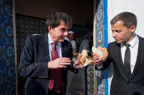 18 mars : Pierre Lellouche montre à Boris Boillon comment on prépare et mange les bombalouni au coeur du village de Sidi Bou Saïd. Après une journée de travail et de rencontres avec les membres du gouvernement tunisien, Pierre Lellouche repart sur les traces de son enfance et va faire découvrir à Boris Boillon, le nouvel ambassadeur de France, le village de Sidi Bou Saïd, son patrimoine architectural et culinaire et faire déguster les fameux Bombalouni (beignets) et thé à la menthe aux pigons du Café des Nattes. Visite de travail de Pierre Lellouche, le secrétaire d’État chargé du Commerce extérieur en Tunisie, accompagné de chefs d’entreprises. 