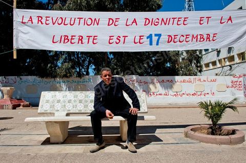 Un des membres du comité de protection de la révolution du 17 décembre 2010 devant une banderolle à Sidi bouzid. Révolution du 17 décembre 2010 et non du 14 janvier 2011.