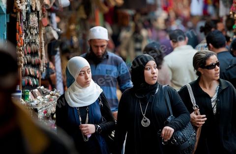 Femmes voilées de noir et homme barbu dasn les souks de la medina de Tunis le vendredi