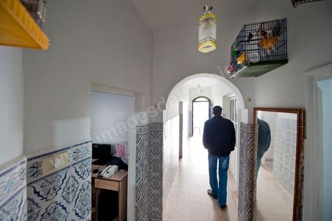 The Bouazizi Family’s New Home

Forced to leave Sidi Bouzid, where the pressure had become too much for them, the Bouazizi family found refuge 260 kilometers away, in Tunis. Mohamed Bouazizi’s mother, the iconic figure of Tunisia’s popular uprising, his sisters, and his two youngest brothers live in a house with blue ceramic tiles—a three-room ground-floor apartment—in the working-class neighborhood of Bousalsa in La Marsa, on the northern outskirts of Tunis. Leila, the 24-year-old eldest sister, is enrolled in a work-study vocational program to become a quality control inspector in the textile industry;  Semia, 19, is preparing for her high school diploma, while Basma, 16, Karim, 14, and Zyed, 8, are still in school. Only the eldest brother, Salem, lives elsewhere, in Sfax. Singled out by some residents of Sidi Bouzid, who accuse her of receiving money from the government, the Bouazizi family produces the lease for their new home, which they plan to rent for six months, through August, at a cost of 360 dinars (180 euros). Soon, the mother promises, they will return to Sidi Bouzid.