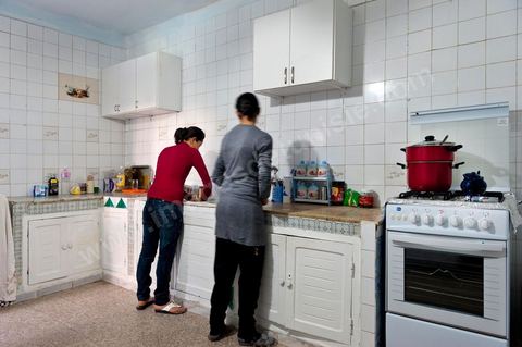 The Bouazizi Family’s New Home

Forced to leave Sidi Bouzid, where the pressure had become too much for them, the Bouazizi family found refuge 260 kilometers away, in Tunis. Mohamed Bouazizi’s mother, the iconic figure of Tunisia’s popular uprising, his sisters, and his two youngest brothers live in a house with blue ceramic tiles—a three-room ground-floor apartment—in the working-class neighborhood of Bousalsa in La Marsa, on the northern outskirts of Tunis. Leila, the 24-year-old eldest sister, is enrolled in a work-study vocational program to become a quality control inspector in the textile industry;  Semia, 19, is preparing for her high school diploma, while Basma, 16, Karim, 14, and Zyed, 8, are still in school. Only the eldest brother, Salem, lives elsewhere, in Sfax. Singled out by some residents of Sidi Bouzid, who accuse her of receiving money from the government, the Bouazizi family produces the lease for their new home, which they plan to rent for six months, through August, at a cost of 360 dinars (180 euros). Soon, the mother promises, they will return to Sidi Bouzid.