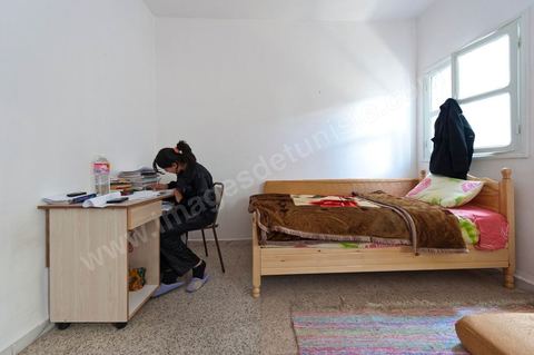 The Bouazizi Family’s New Home

Forced to leave Sidi Bouzid, where the pressure had become too much for them, the Bouazizi family found refuge 260 kilometers away, in Tunis. Mohamed Bouazizi’s mother, the iconic figure of Tunisia’s popular uprising, his sisters, and his two youngest brothers live in a house with blue ceramic tiles—a three-room ground-floor apartment—in the working-class neighborhood of Bousalsa in La Marsa, on the northern outskirts of Tunis. Leila, the 24-year-old eldest sister, is enrolled in a work-study vocational program to become a quality control inspector in the textile industry;  Semia, 19, is preparing for her high school diploma, while Basma, 16, Karim, 14, and Zyed, 8, are still in school. Only the eldest brother, Salem, lives elsewhere, in Sfax. Singled out by some residents of Sidi Bouzid, who accuse her of receiving money from the government, the Bouazizi family produces the lease for their new home, which they plan to rent for six months, through August, at a cost of 360 dinars (180 euros). Soon, the mother promises, they will return to Sidi Bouzid.