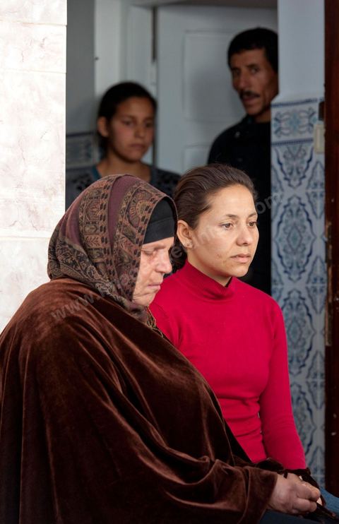 The Bouazizi Family’s New Home

Forced to leave Sidi Bouzid, where the pressure had become too much for them, the Bouazizi family found refuge 260 kilometers away, in Tunis. Mohamed Bouazizi’s mother, the iconic figure of Tunisia’s popular uprising, his sisters, and his two youngest brothers live in a house with blue ceramic tiles—a three-room ground-floor apartment—in the working-class neighborhood of Bousalsa in La Marsa, on the northern outskirts of Tunis. Leila, the 24-year-old eldest sister, is enrolled in a work-study vocational program to become a quality control inspector in the textile industry;  Semia, 19, is preparing for her high school diploma, while Basma, 16, Karim, 14, and Zyed, 8, are still in school. Only the eldest brother, Salem, lives elsewhere, in Sfax. Singled out by some residents of Sidi Bouzid, who accuse her of receiving money from the government, the Bouazizi family produces the lease for their new home, which they plan to rent for six months, through August, at a cost of 360 dinars (180 euros). Soon, the mother promises, they will return to Sidi Bouzid.