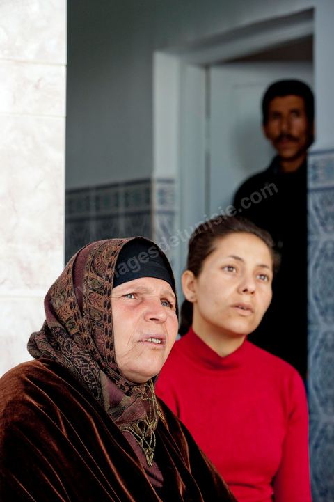The Bouazizi Family’s New Home

Forced to leave Sidi Bouzid, where the pressure had become too much for them, the Bouazizi family found refuge 260 kilometers away, in Tunis. Mohamed Bouazizi’s mother, the iconic figure of Tunisia’s popular uprising, his sisters, and his two youngest brothers live in a house with blue ceramic tiles—a three-room ground-floor apartment—in the working-class neighborhood of Bousalsa in La Marsa, on the northern outskirts of Tunis. Leila, the 24-year-old eldest sister, is enrolled in a work-study vocational program to become a quality control inspector in the textile industry;  Semia, 19, is preparing for her high school diploma, while Basma, 16, Karim, 14, and Zyed, 8, are still in school. Only the eldest brother, Salem, lives elsewhere, in Sfax. Singled out by some residents of Sidi Bouzid, who accuse her of receiving money from the government, the Bouazizi family produces the lease for their new home, which they plan to rent for six months, through August, at a cost of 360 dinars (180 euros). Soon, the mother promises, they will return to Sidi Bouzid.