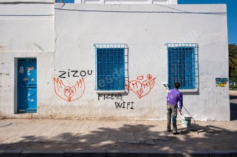 Scène quotidienne depuis la révolution de nettoyage des grafitis sur les murs des bâtiments de la ville