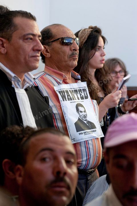 20 juin 2011 : Homme contestant le procès par contumace avec une pancarte Wanted Ben Ali dans la salle du procès. Tribunal de première Instance de Tunis, Chambre criminelle, la justice tunisienne a entamé aujourd’hui le procès de Benali et de sa femme en son absence, cette audience est la première parmi les 93 procédures engagées contre le président déchu, dont 35 relèvent de la justice militaire.Le procès d’aujourd’hui concerne l'affaire du palais de Sidi Dherif où une importante quantité de devises et des bijoux de valeur ont été saisis. Ben Ali est également accusé de  détention d'armes et de possession de stupéfiants, saisis au palais de Carthage.  Il est passible de peines allant de 5 à 20 ans de prison. 