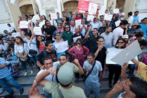 10 août 2011 : Quelque trois cents personnes ont de nouveau manifesté ce matin dans le centre de Tunis pour "une justice indépendance" et une rupture avec l'ancien régime de Ben Ali: "Le peuple veut une justice indépendante", "Ni liberté, ni impunité pour les criminels", ont scandé les manifestants tapant dans leurs mains sur les marches du Théâtre, au coeur de la capitale tunisienne.  Certains manifestaient sous la bannière de partis politiques, d'autres en tant qu'indépendants ou syndicalistes se tenaient en retrait sur le terre-plein de l'Avenue centrale Habib Bourguiba, contenus par de nombreux effectifs de la police. "Nous sommes d'accord sur les revendications: justice indépendante, non à l'impunité, information libre et purge des résidus de l'ancien régime", a déclaré un enseignant syndicaliste dans le camp des indépendants : "Nous voulons couper les ponts avec le régime de Ben Ali", affirmant que les protestations se poursuivront jusqu'au départ des symboles du système déchu encore en place". Sur des panneaux, les manifestants ont dénoncé la fuite d'une figure emblématique de la propagande sous Ben Ali, Saida Agrebi, qui était sous le coup d'une plainte en justice, et le retour sur la scène de certains membres du Rassemblement constitutionnel démocratique, parti de Ben Ali dissous après la chute de son régime le 14 janvier. "Nous avons le devoir de ne pas laisser confisquer la révolution, d'être fidèle aux martyrs", a scandé un responsable politique.