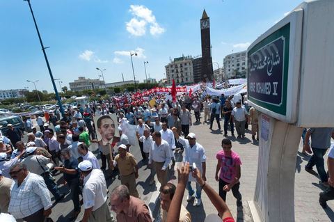 15 août 2011 : L'Union Générale Tunisienne du Travail a organisé une marche de protestation ''pour la réalisation des objectifs de la révolution et en mémoire des martyrs'' qui a débuté lundi 15 août 2011 à midi devant la bourse du travail à Tunis avant de parcourir l'avenue Mohamed V et de se disperser devant la place des droits de l'Homme.Ont participé à cette marche, les structures régionales et locales de base de l'Union, des partis politiques, des personnalités nationales, des composantes de la société civile, des intellectuels et des artistes.Les manifestants ont exprimé des revendications à caractère social et politique exigeant notamment le départ du Gouvernement de transition et de demander des comptes aux symboles de la corruption, notamment par une restitution des avoirs du peuple, spoliés par la famille du président déchu, la réforme de la Justice et l'emploi aux chômeurs.Les manifestants ont dénoncé la hausse des prix et appelé au respect des principes de la révolution et à la fidélité au sang des martyrs.La marche a été marquée par un arrêt symbolique devant le siège de l'ancien Rassemblement Constitutionnel Démocratique dissous."La Tunisie libre et les voleurs dehors", "Peuple, révolte-toi contre les restants de la dictature", "Pas de liberté, pas de retour, pour les bandes du destour" ont scandé les manifestants.