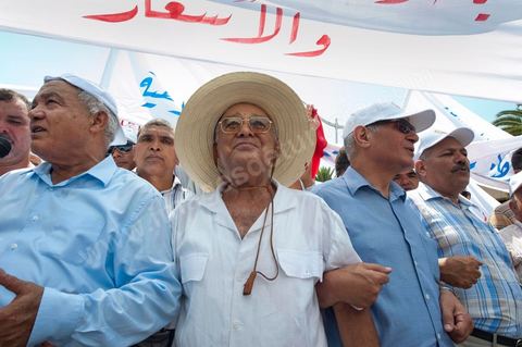 15 août 2011 : Abdessalem JRAD, Secrétaire Général de l'UGGT et Ahmed BRAHIM, secrétaire général du Parti démocrate Ettajdid à la maNif de l'UGGT. L'Union Générale Tunisienne du Travail a organisé une marche de protestation ''pour la réalisation des objectifs de la révolution et en mémoire des martyrs'' qui a débuté lundi 15 août 2011 à midi devant la bourse du travail à Tunis avant de parcourir l'avenue Mohamed V et de se disperser devant la place des droits de l'Homme.Ont participé à cette marche, les structures régionales et locales de base de l'Union, des partis politiques, des personnalités nationales, des composantes de la société civile, des intellectuels et des artistes.Les manifestants ont exprimé des revendications à caractère social et politique exigeant notamment le départ du Gouvernement de transition et de demander des comptes aux symboles de la corruption, notamment par une restitution des avoirs du peuple, spoliés par la famille du président déchu, la réforme de la Justice et l'emploi aux chômeurs.Les manifestants ont dénoncé la hausse des prix et appelé au respect des principes de la révolution et à la fidélité au sang des martyrs.La marche a été marquée par un arrêt symbolique devant le siège de l'ancien Rassemblement Constitutionnel Démocratique dissous."La Tunisie libre et les voleurs dehors", "Peuple, révolte-toi contre les restants de la dictature", "Pas de liberté, pas de retour, pour les bandes du destour" ont scandé les manifestants.